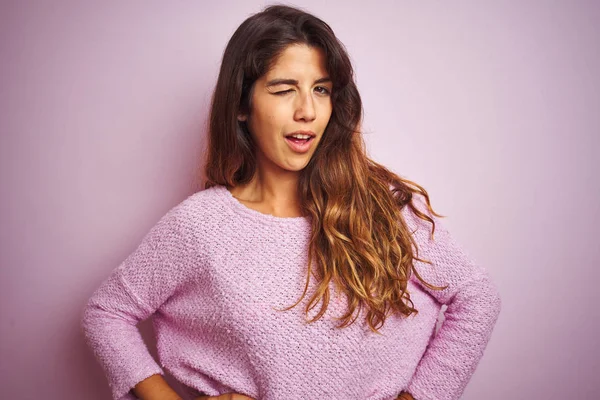 若いです美しいです女性身に着けていますセーター上のピンク隔離された背景ウィンク見ますザカメラとともにセクシー式 陽気で幸せな顔 — ストック写真
