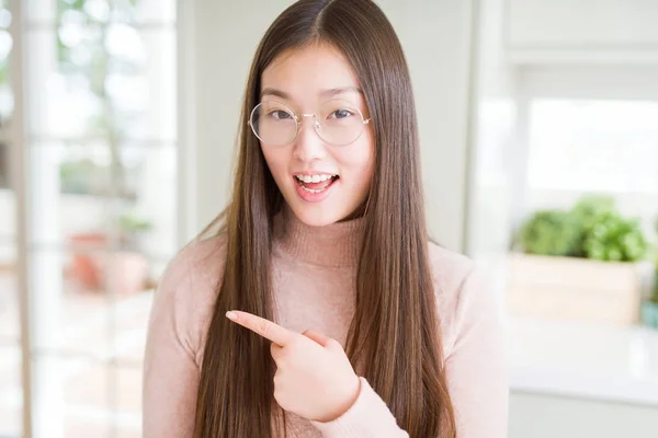 美丽的亚洲女人戴着欢快的眼镜 脸上带着手和手指指着的微笑 脸上带着快乐和自然的表情站在一边 — 图库照片