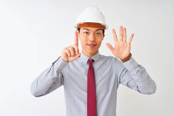 中国の建築家の男を着てネクタイとヘルメットの上に立って孤立した白い背景を示すと指の番号6で指摘しながら 自信と幸せ笑顔 — ストック写真