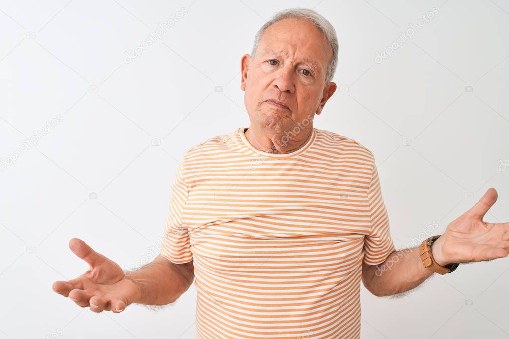 Senior grey-haired man wearing striped t-shirt standing over isolated white background clueless and confused with open arms, no idea concept.