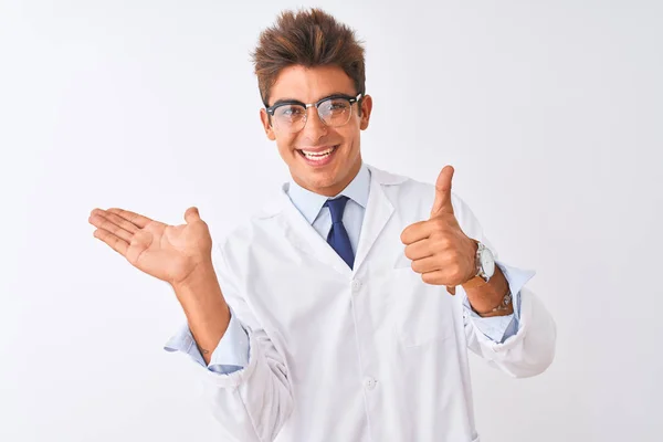 年轻英俊的科学家 戴着眼镜 披着外套 站在与世隔绝的白色背景上 手举着手 竖起大拇指 做着个好手势 笑容满面 兴高采烈 — 图库照片