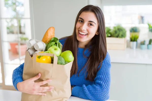 Молодая Красивая Женщина Улыбается Держа Дома Бумажный Пакет Полный Продуктов — стоковое фото