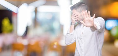 Genç iş adam elleriyle gözlerini kapsayan izole arka plan üzerinde ve stop jest ile acı ve korku ifadesi. Utandım ve negatif kavramı.