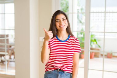 Güzel genç kadın gülümseyen heyecanlı yapıyor başparmak kadar sembolü, ok jest