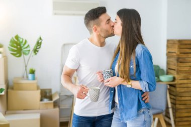 Güzel çift yeni bir eve hareketli, neşeli bir fincan kahve içme gülümseyen