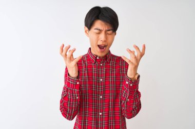 İzole edilmiş beyaz arka planda dikilmiş, kollarını kaldırmış ve gözleri kapalı heyecanlı bir şekilde çılgın ve çılgın bir başarıyı kutlayan sıradan kırmızı tişörtlü genç Çinli bir adam. Kazanan konsept