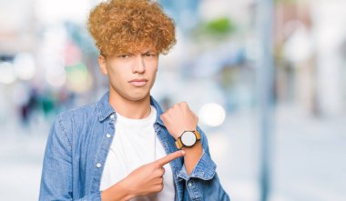 İşaret seyretmek zaman, sabırsızlık, üzgün ve kızgın için son tarih gecikme için acele denim ceket giyen afro saçlı Genç yakışıklı adam