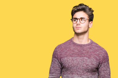 Yakışıklı delikanlı görünümlü yan ve dik dik bakma uzağa düşünce gülümseyen izole arka plan üzerinde gözlük.