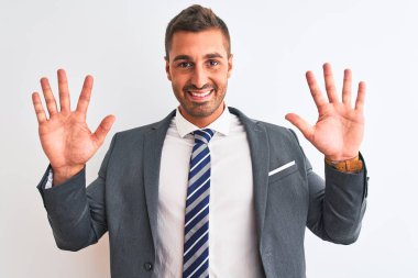 Takım elbiseli ve kravatlı genç yakışıklı iş adamı on numarayı gösterip işaret ederken kendinden emin ve mutlu bir şekilde gülümsüyor..