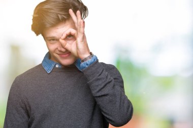 Genç yakışıklı zarif adam gülümsüyor, parmakları ile mutlu yüz üzerinden seyir göz el ile ok jest yapıyor izole arka plan üzerinde.