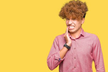 Genç yakışıklı iş adam ile afro saç dokunmadan ağız ile el ağrılı ifade nedeniyle diş ağrısı veya diş hastalığı dişlerde. Dişçi konsepti.