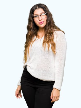 Yüzünde ciddi bir ifade ile gözlük takan genç güzel kadın. Basit ve doğal kameraya bakıyor.