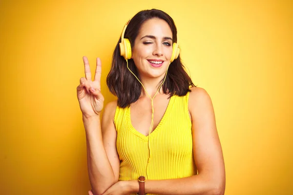 Fiatal Gyönyörű Zenét Hallgat Fülhallgatóval Sárga Elszigetelt Háttér Mosolyog Boldog — Stock Fotó