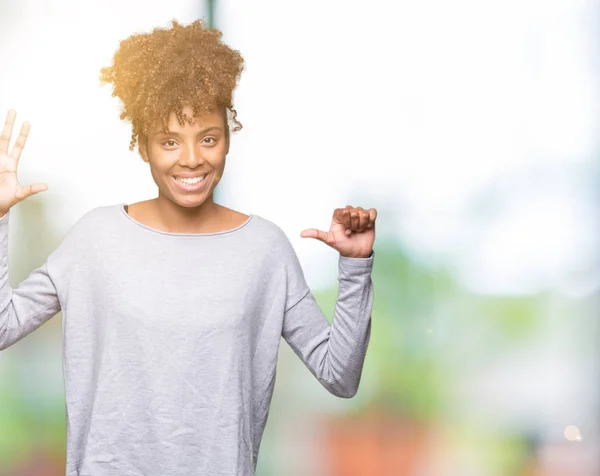 Beautiful young african american woman over isolated background showing and pointing up with fingers number six while smiling confident and happy.