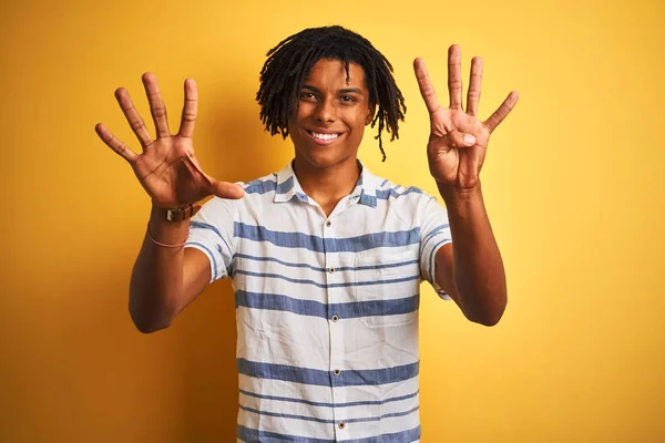 アフリカ系アメリカ人の男ですドレッドロックを身に着けていますストライプシャツ上の隔離された黄色の背景が表示され 指番号9で指摘しながら 自信と幸せ — ストック写真