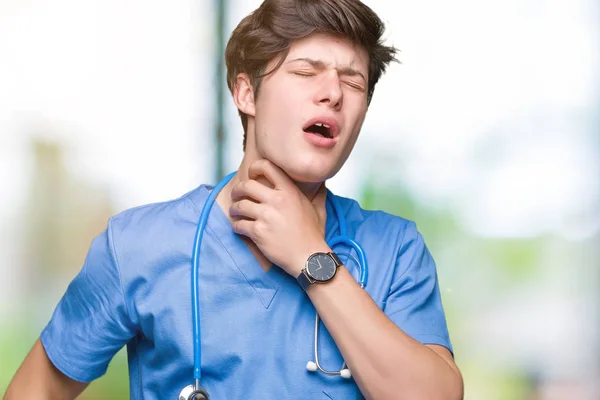 年轻的医生穿着医疗制服在孤立的背景触摸疼痛的脖子 咽喉痛的流感 血块和感染 — 图库照片