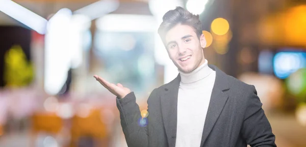 Elegante Jongeman Winterjas Dragen Geïsoleerde Achtergrond Lacht Vrolijk Presenteren Wijzen — Stockfoto