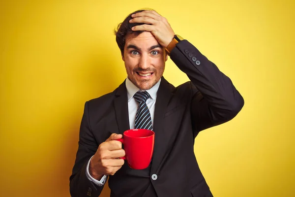 Młody Przystojny Biznesmen Pijący Czerwoną Filiżankę Kawy Odizolowanym Żółtym Tle — Zdjęcie stockowe
