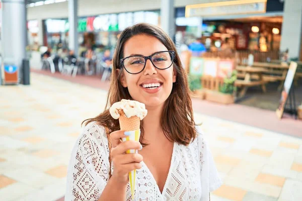 若いです美しい女性食べるアイスクリームコーンでショッピングセンターで夏の晴れた日に休日 — ストック写真