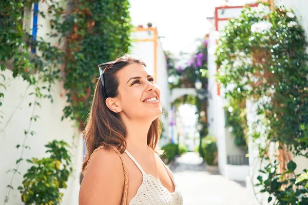 Young beautiful woman at the colorful village of Puerto de Mogan, smiling happy at the street on summer holidays