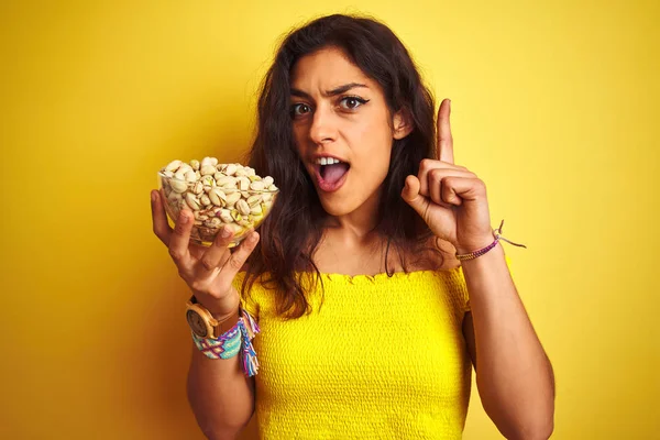 Jonge Mooie Vrouw Houden Kom Met Pistaches Geïsoleerde Gele Achtergrond — Stockfoto