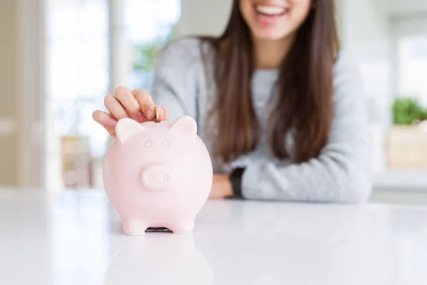 Jonge Vrouw Glimlachend Het Zetten Van Een Munt Binnen Piggy — Stockfoto