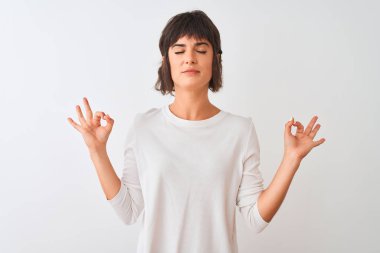 Genç güzel kadın izole beyaz arka plan üzerinde duran rahat t-shirt giyen rahat rahat ve gözleri parmakları ile meditasyon jest yapıyor kapalı gülümseyerek. Yoga konsepti.