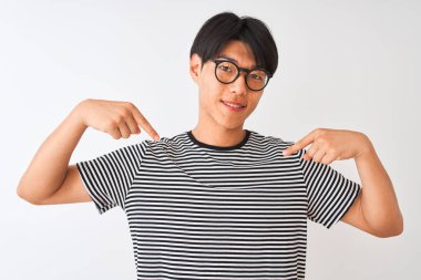 Gözlüklü ve donanma tişörtlü Çinli bir adam izole edilmiş beyaz arka planda duruyor. Yüzünde bir gülümsemeyle, gururlu ve mutlu bir şekilde kendini gösteriyor..