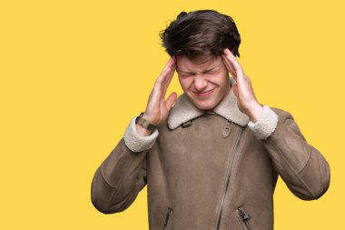 Genç yakışıklı adam giyen kış ceket çünkü umutsuz ve stresli baş ağrısı acı izole arka plan üzerinde ağrı ve Migren. Ellerini kafasına.