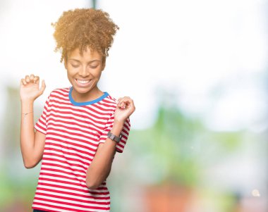 Güzel genç Afro-Amerikan kadın izole arka plan dans mutlu ve neşeli, hareketli rahat ve kendinden emin müzik gülümseyen üzerinde