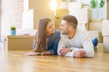 Yeni evin katında yatan genç güzel çift, yeni daireye taşınmak için çok mutlu aşk gülümsüyor