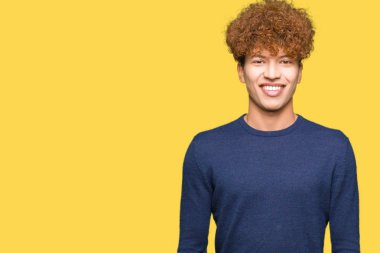 Yüzünde mutlu ve serin bir gülümseme ile afro saçlı genç yakışıklı adam. Şanslı kişi.