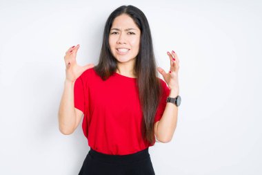 Güzel esmer kadın, izole edilmiş arka planda kırmızı tişört giyiyor öfkeden çıldırmış bağırıyor, elleri boğazlamaya çalışıyor, deli gibi bağırıyor.