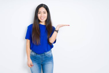 Güzel esmer kadın izole edilmiş arka planda gülümseyen neşeli sunum yapan ve avuç içi kameraya bakan..