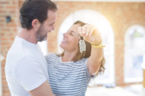 Middle age senior romantic couple holding and showing house keys