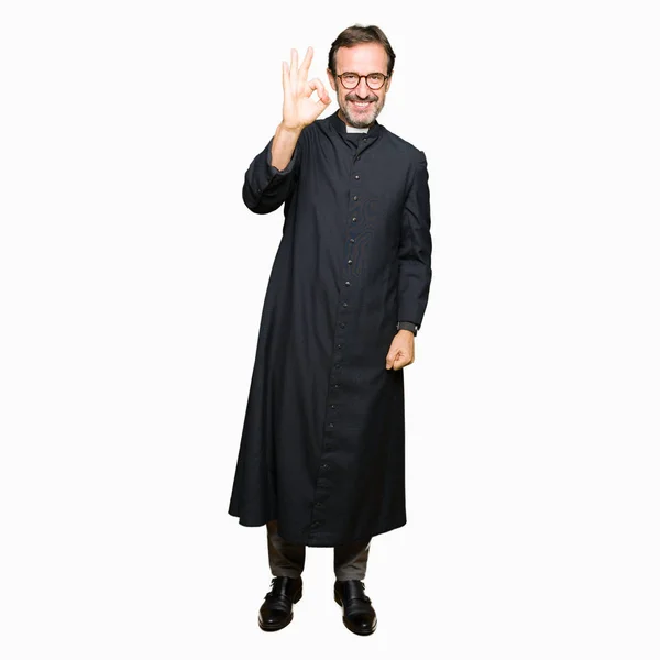 中年牧师男子穿着天主教长袍微笑积极做确定的迹象与手和手指 成功的表达 — 图库照片