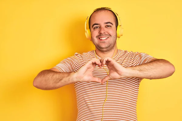 Joven Escuchando Música Usando Auriculares Parados Sobre Fondo Amarillo Aislado —  Fotos de Stock