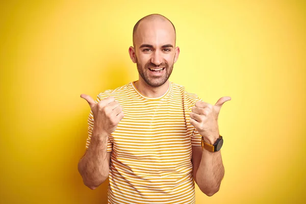 턱수염을 기르고 노란색 바탕에 티셔츠를 대머리 남자가 손으로 긍정적 행동을 — 스톡 사진