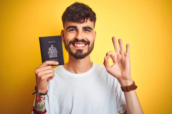 Jovem Com Tatuagem Vestindo Passaporte Canadense Sobre Fundo Amarelo Isolado — Fotografia de Stock