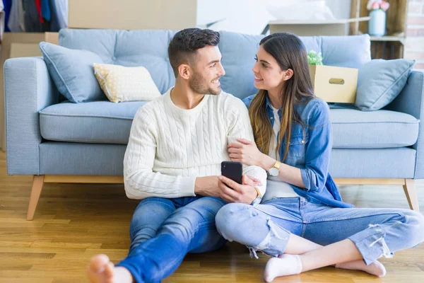 Junges Paar Sitzt Mit Smartphone Auf Dem Boden Des Neuen — Stockfoto