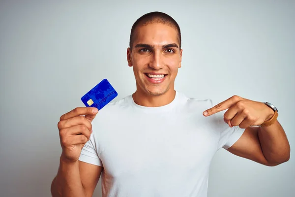 Νέος Όμορφος Άνδρας Κρατώντας Πιστωτική Κάρτα Πάνω Από Λευκό Απομονωμένο — Φωτογραφία Αρχείου