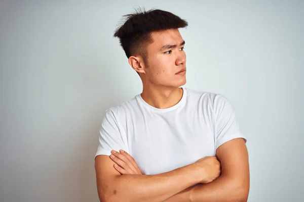 若いですアジアの中国人男性を着てTシャツを身に着けています孤立した白い背景の上に立って腕を横に見て確信と自信 — ストック写真
