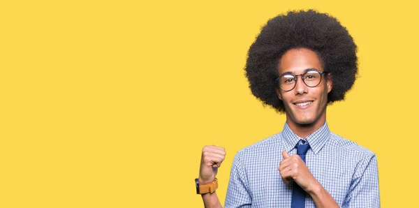 若いアフリカ系アメリカ人ビジネスの男性とアフロの髪を着てメガネ自信の笑みを浮かべて手と親指 裏側を指す — ストック写真