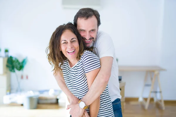 Старша пара середнього віку переїжджає в новий будинок, посміхаючись щасливим в — стокове фото