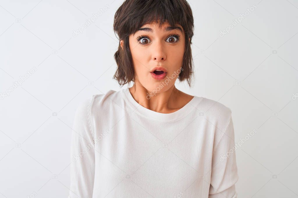 Young beautiful woman wearing casual t-shirt standing over isolated white background scared in shock with a surprise face, afraid and excited with fear expression