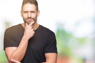 Yakışıklı delikanlı emin çapraz kollar ve çeneme kaldırdı el ile gülümseme ile kameraya bakarak izole arka plan üzerinde. Pozitif düşünce.