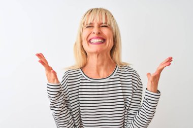 Orta yaşlı bir kadın, donanma çizgili tişört giyip izole edilmiş beyaz arka planda duruyor ve başarıyı kutluyor. Kolları havada, gözleri kapalı, heyecanlı bir şekilde çığlık atıyor. Kazanan konsept