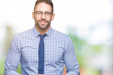 Arka plan eller birlikte üzerinde gözlük takan genç iş adamı izole ve rahat ve neşeli gülümseyen parmak çarpı işareti. Başarı ve iyimser