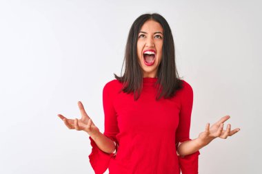 İzole edilmiş beyaz arka planda duran kırmızı elbiseli genç ve güzel Çinli kadın kızgın ve sinirli bir şekilde bağırıyor ve agresif bir ifade ve kolla bağırıyor. Hayal kırıklığı konsepti.