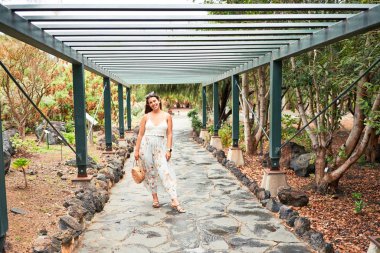 Güneşli bir yaz gününde yeşil parkta mutlu ve neşeli gülümseyen güzel bir kadın.